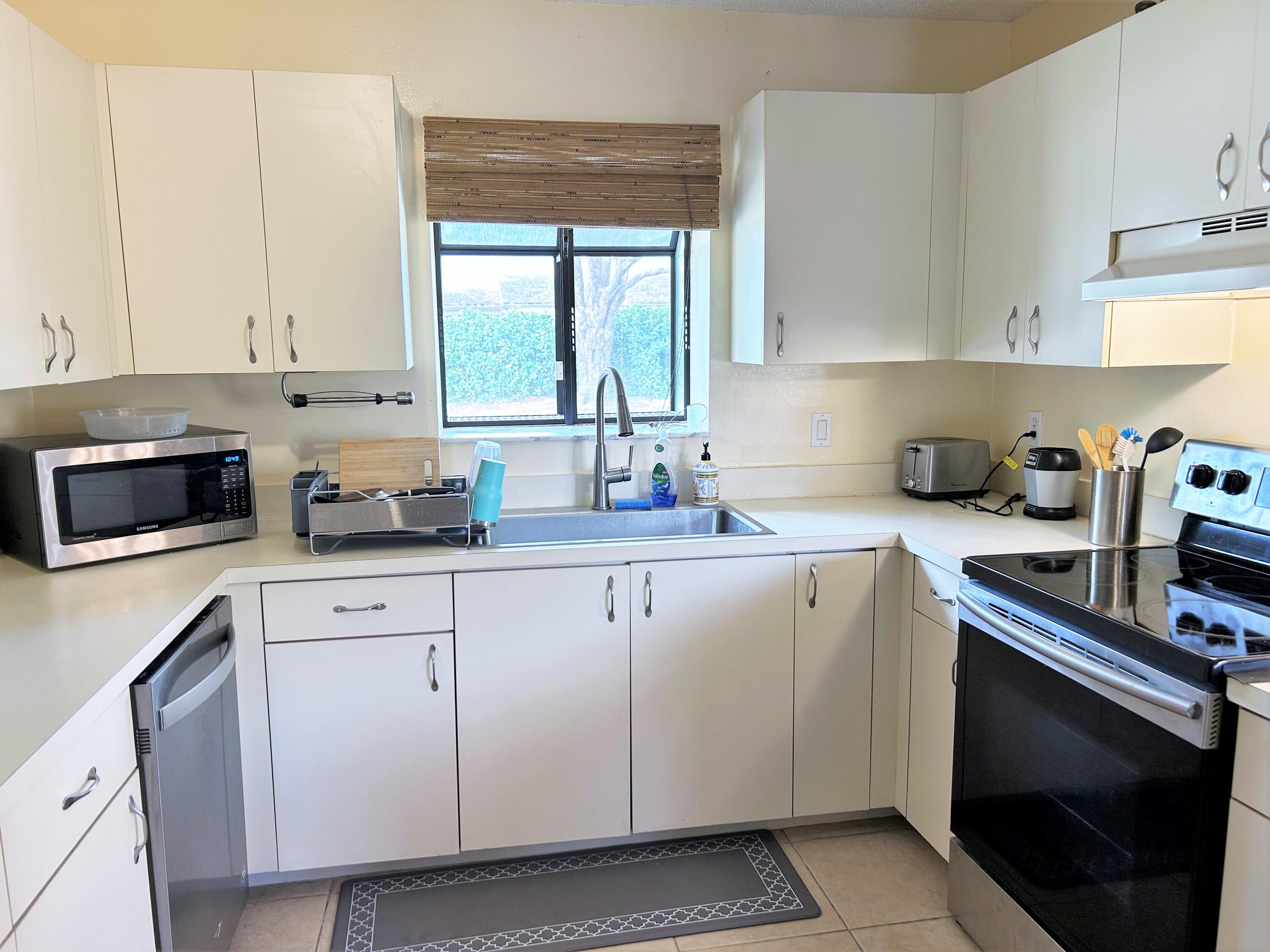 201 Meadows Drive Boynton Beach, FL 33436 - Photo 6 of 40 a kitchen with cabinets appliances a sink and a window