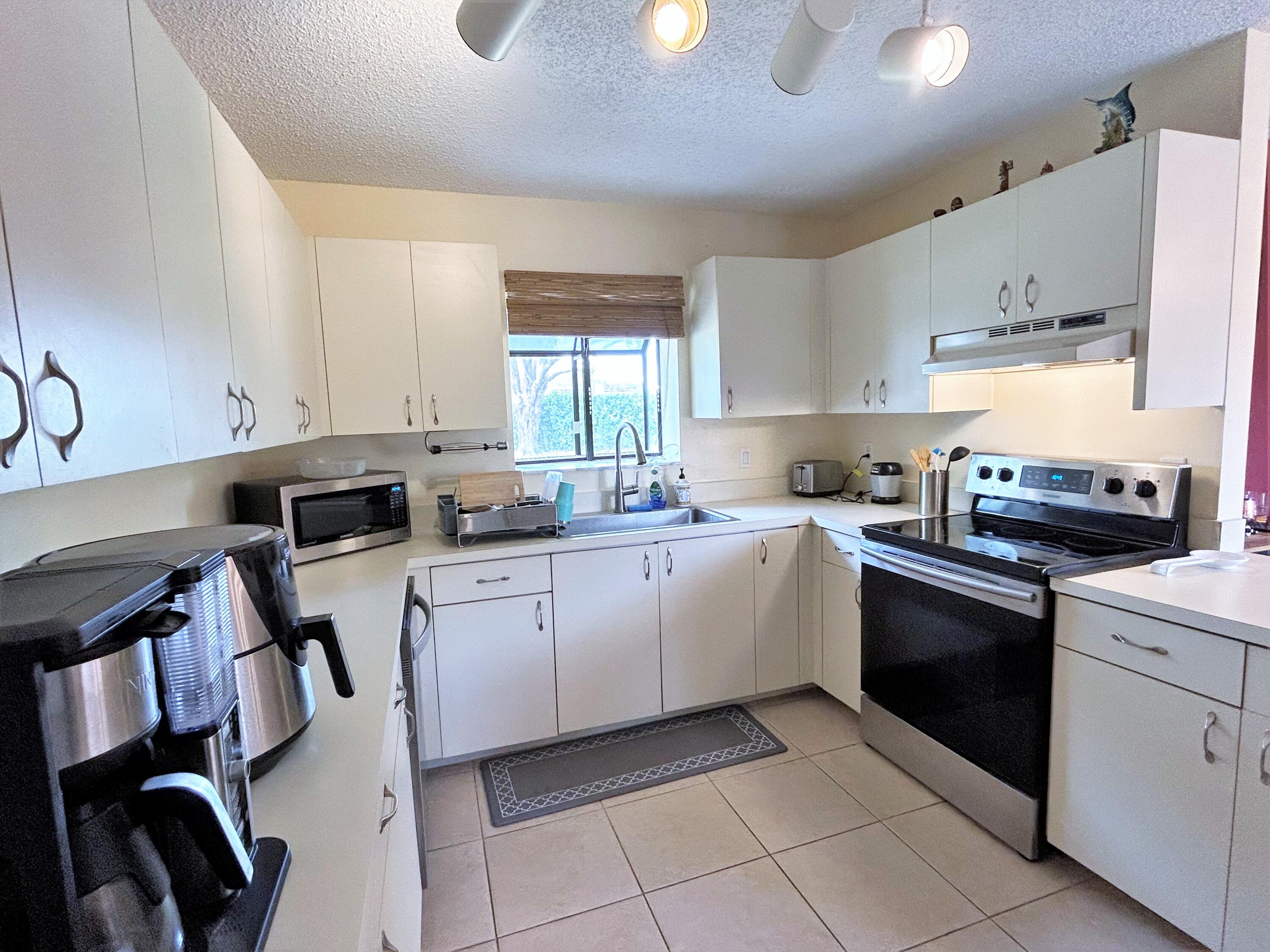 201 Meadows Drive Boynton Beach, FL 33436 - Photo 9 of 40 a kitchen with a sink window and cabinets