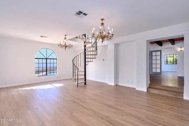 a kitchen with stainless steel appliances granite countertop a stove a sink dishwasher and a refrigerator with wooden floor