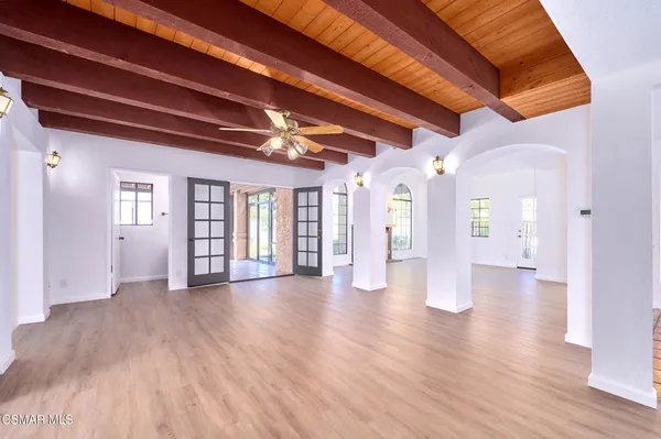 an empty room with floor to ceiling windows and fireplace