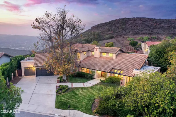 an aerial view of a house with yard and mountain view in back