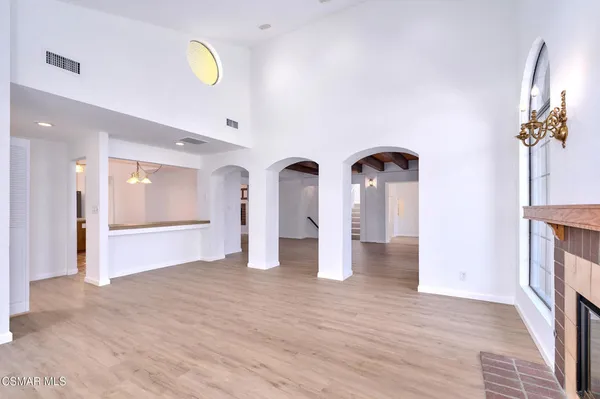 a view of a bedroom with wooden floor and windows