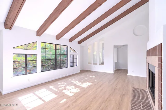 a view of a livingroom with wooden floor and a fireplace