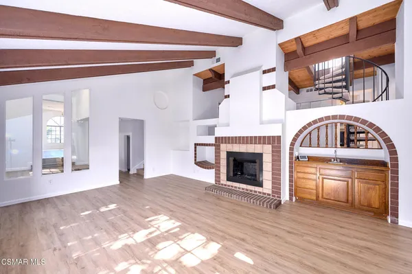 a view of a livingroom with wooden floor and a fireplace