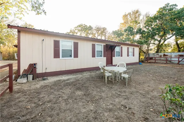 a backyard of a house with table and chairs