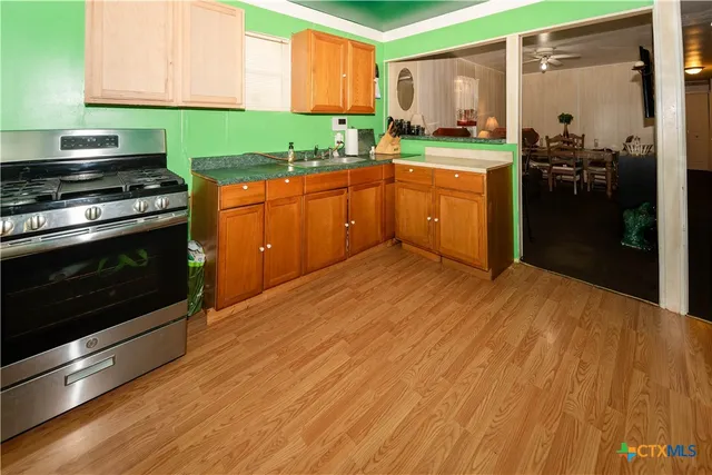 a kitchen with stainless steel appliances granite countertop a stove a sink and a refrigerator