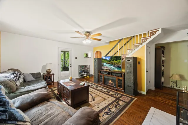 a living room with furniture a flat screen tv and a table