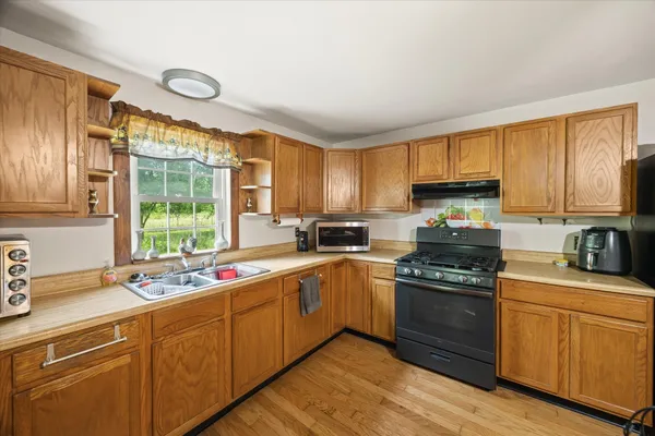 a kitchen with a sink stove top oven and cabinets