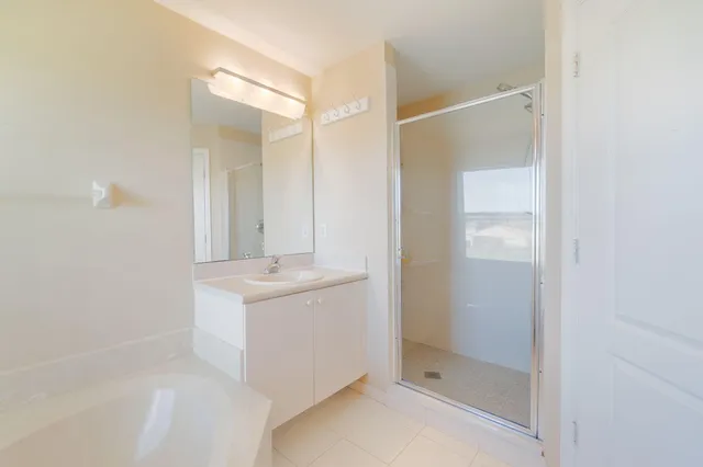 a bathroom with a shower sink and mirror