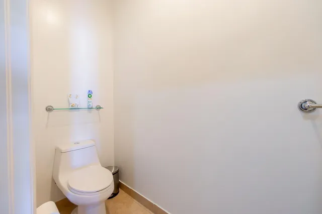 a white toilet sitting next to a white wall