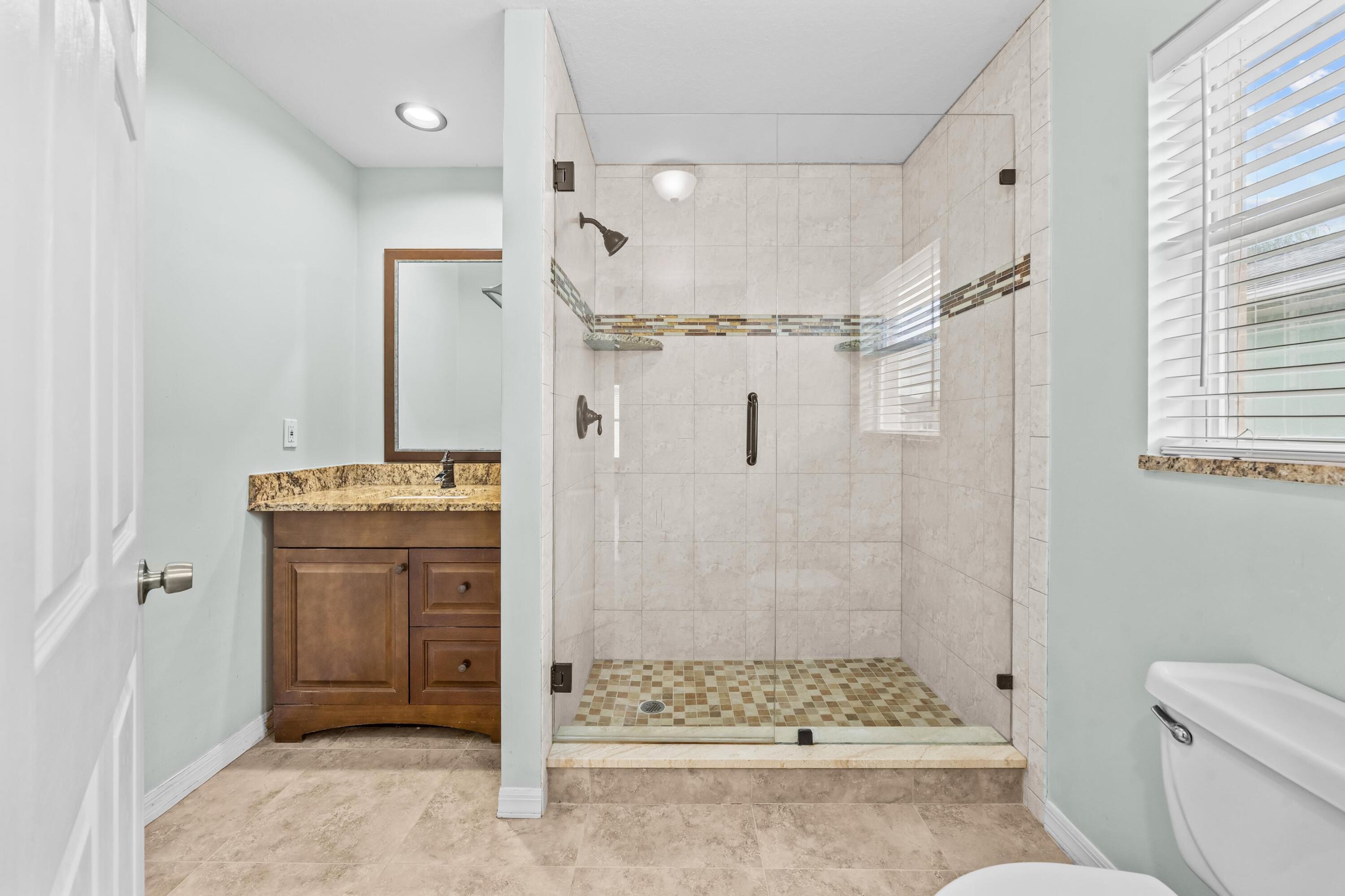 5925 Foxtail Way Fort Pierce, FL 34982 - Photo 11 of 29 a bathroom with a granite countertop shower sink vanity and toilet