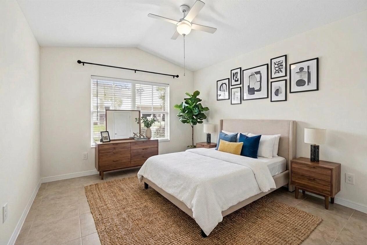 5925 Foxtail Way Fort Pierce, FL 34982 - Photo 17 of 29 a bedroom with a large bed and a chandelier