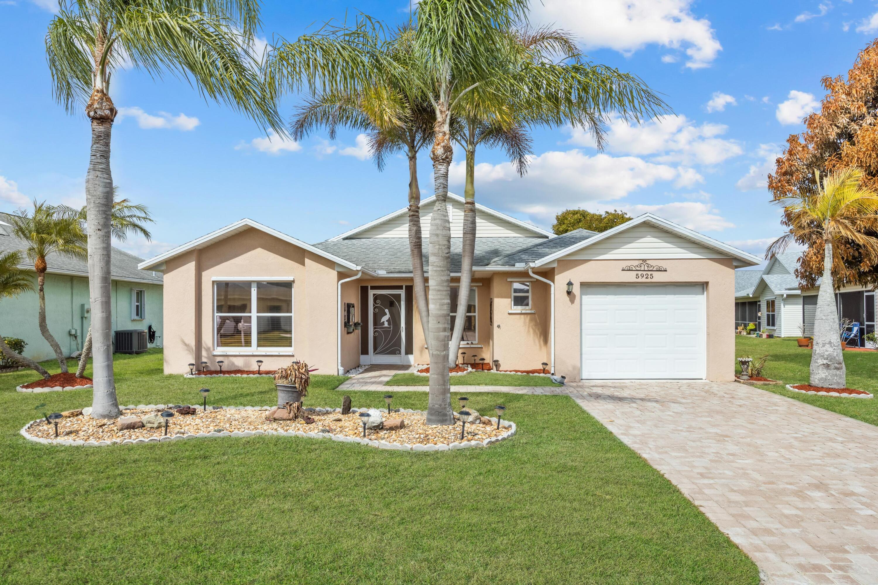 5925 Foxtail Way Fort Pierce, FL 34982 - Photo 2 of 29 a front view of a house with a yard and porch