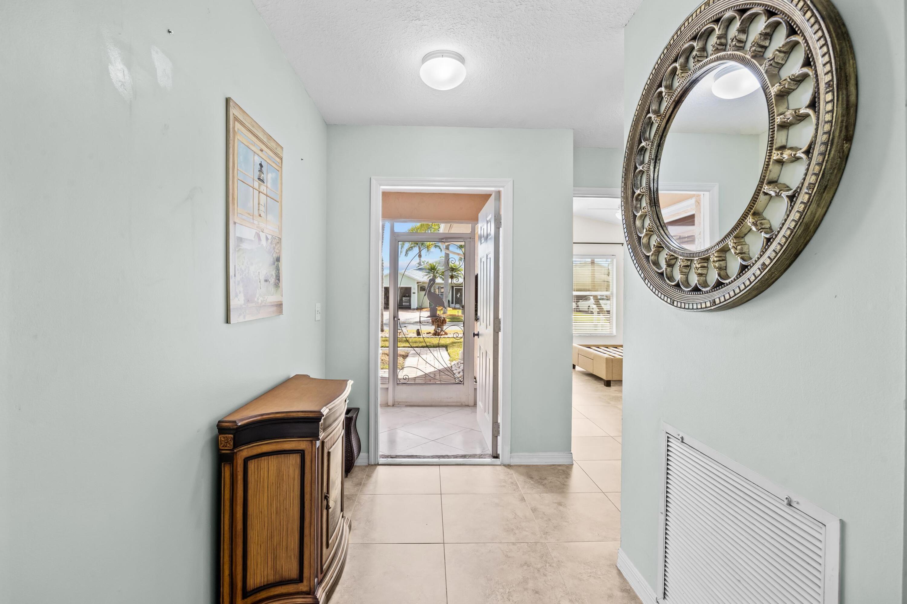 5925 Foxtail Way Fort Pierce, FL 34982 - Photo 28 of 29 an entryway with wooden floor and a mirror