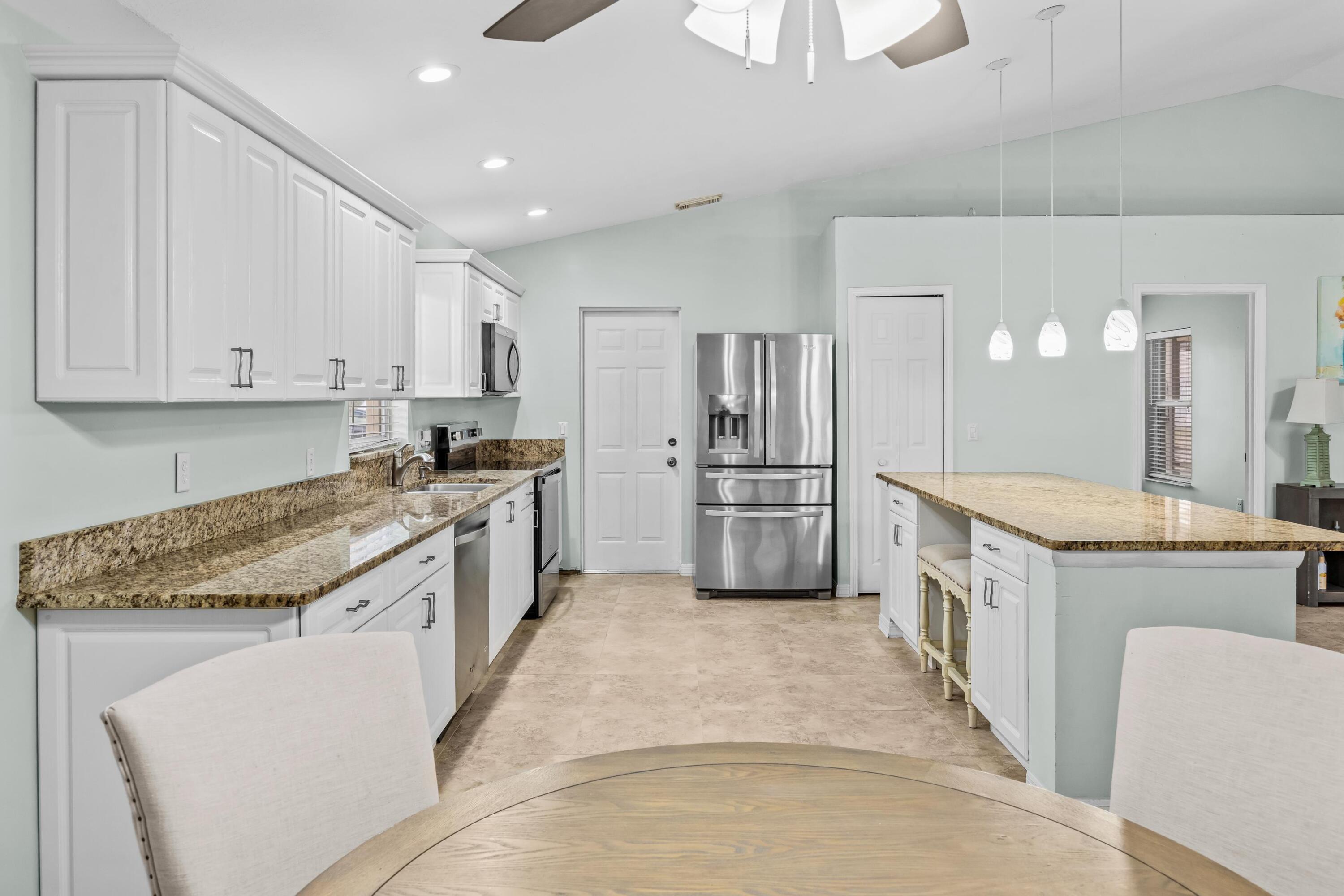 5925 Foxtail Way Fort Pierce, FL 34982 - Photo 8 of 29 a kitchen with granite countertop a sink a counter top space stainless steel appliances and cabinets