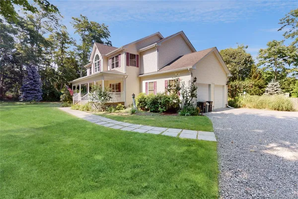a view of house with garden and tall trees
