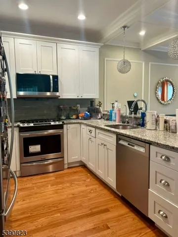a kitchen with granite countertop a stove a sink and a microwave