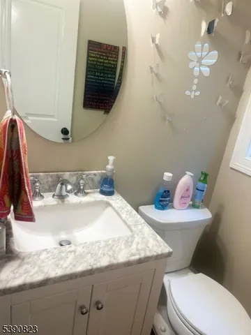 a bathroom with a granite countertop sink a mirror and toilet