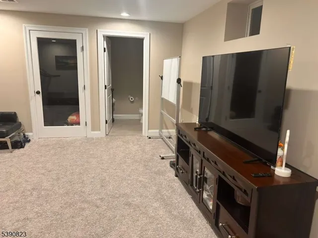 a living room with stainless steel appliances furniture and a flat screen tv