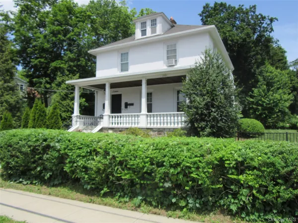 a front view of a house with yard and green space
