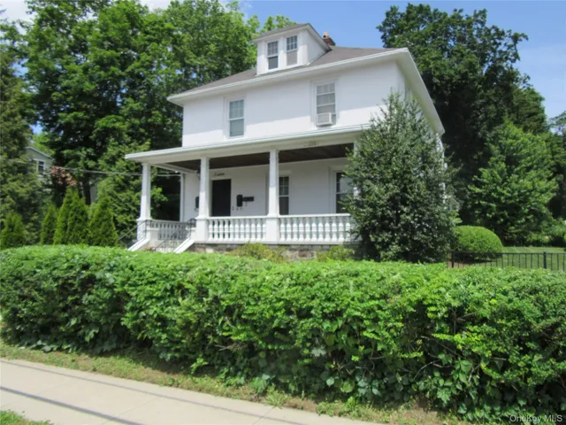 a front view of a house with yard and green space