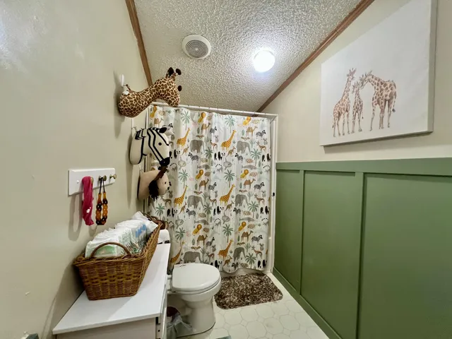 a bathroom with a toilet sink and shower curtain
