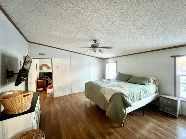 a bedroom with a bed and wooden floor