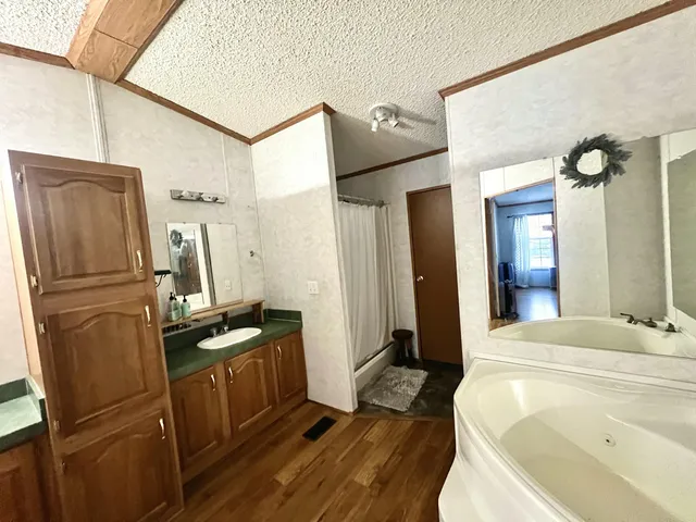 a bathroom with a tub sink and mirror