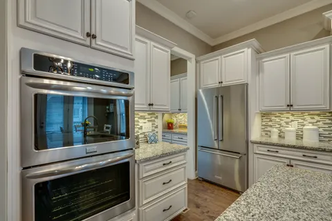 a kitchen with stainless steel appliances white cabinets and a refrigerator