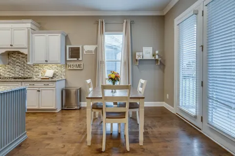 a dining room with wooden floor and stainless steel appliances
