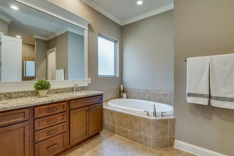 a bathroom with a granite countertop bathtub sink and mirror