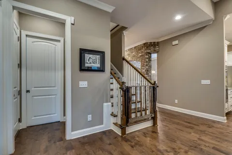 a view of a hallway with entryway wooden floor and stairs