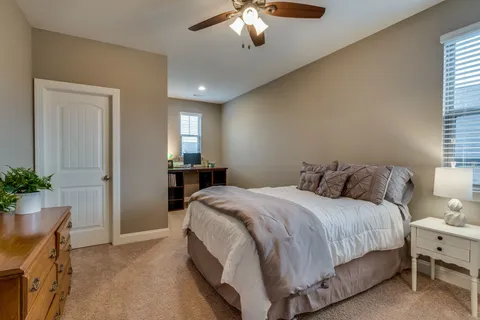 a spacious bedroom with a bed and a chandelier
