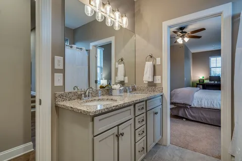 a en suite bathroom with a granite countertop sink and a mirror