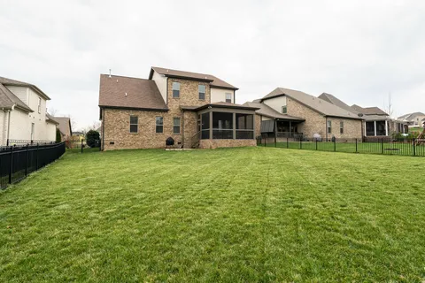 a view of a house with a big yard and large trees