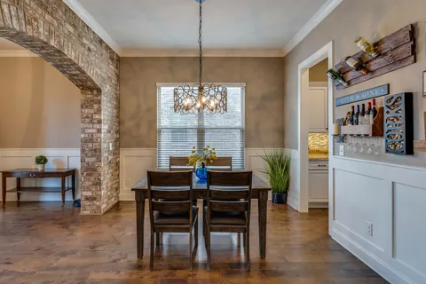 a dining room with furniture a chandelier and wooden floor
