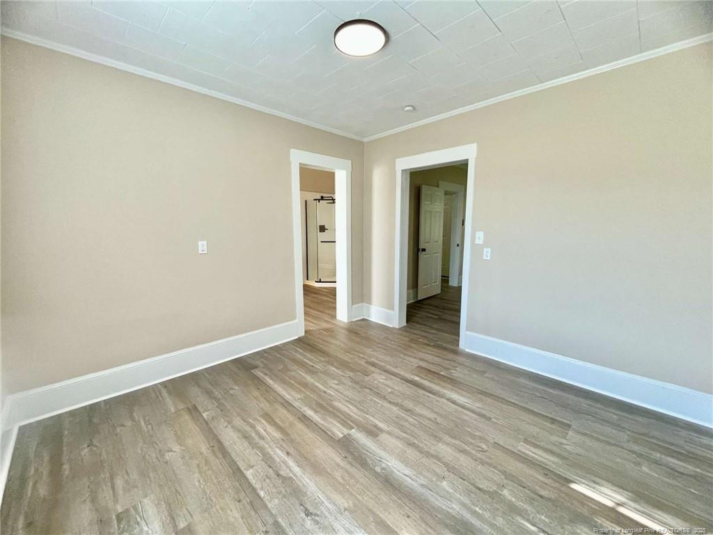 416 Old Maxton Road Raeford, NC 28376 - Photo 21 of 26 an empty room with wooden floor and windows
