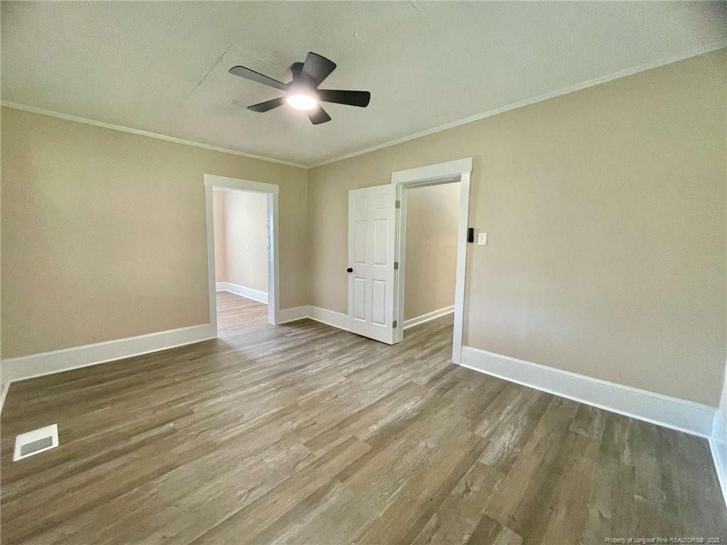 416 Old Maxton Road Raeford, NC 28376 - Photo 23 of 26 an empty room with wooden floor and ceiling fan