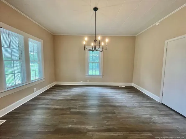 a view of a room with window wooden floor and front door