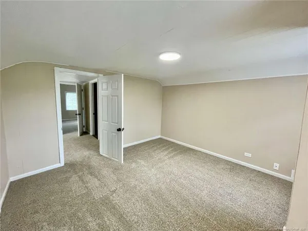 an empty room with an entryway and closet area