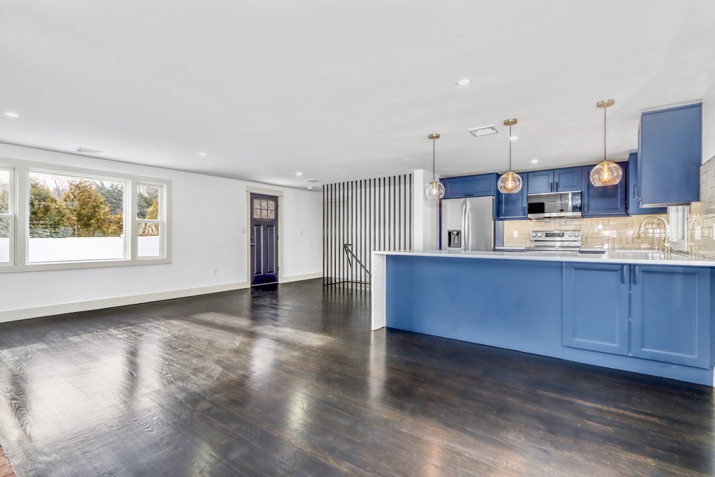 11 Spring Lane Saugus, MA 01906 - Photo 10 of 31 a kitchen with stainless steel appliances granite countertop a sink a stove cabinets and wooden floor