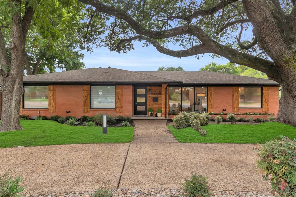 View of front of home featuring a front lawn, roof with shingles, and brick siding