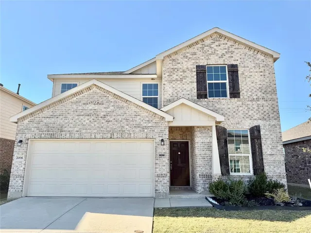 a front view of a house with plants