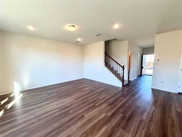 a view of an empty room with wooden floor