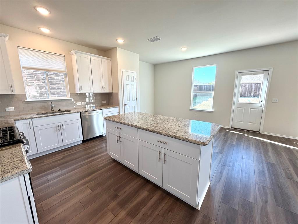 2006 Hummingbird Street Princeton, TX 75407 - Photo 7 of 23 a large kitchen with granite countertop a large window a sink and stainless steel appliances
