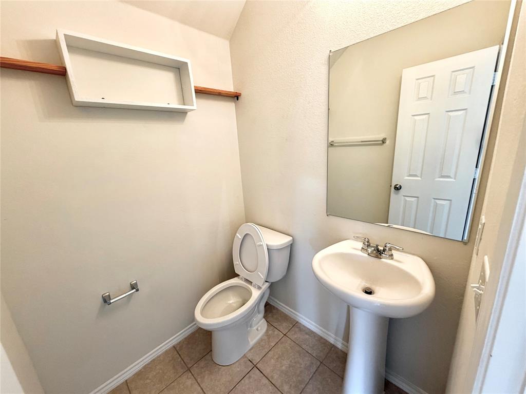 2006 Hummingbird Street Princeton, TX 75407 - Photo 10 of 23 a bathroom with a toilet sink and mirror
