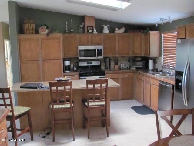 1829 West Irvine Road Phoenix, AZ 85086 - Photo 7 of 33 a kitchen with stainless steel appliances granite countertop a stove top oven a sink a dining table and chairs