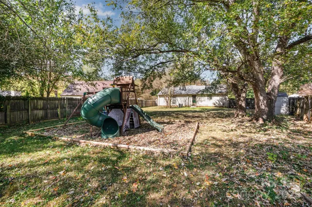 a view of a yard with wooden fence
