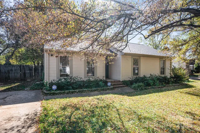 a front view of house with yard and trees around