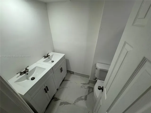 a white toilet sitting next to a bathroom sink